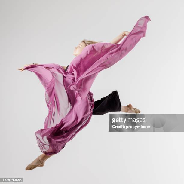 tänzerin auf grauem hintergrund mit textil in der luft - moderner tanz stock-fotos und bilder