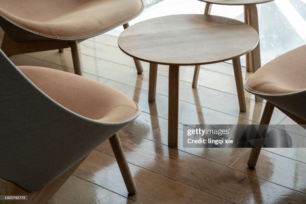 Wooden chairs around a round coffee table