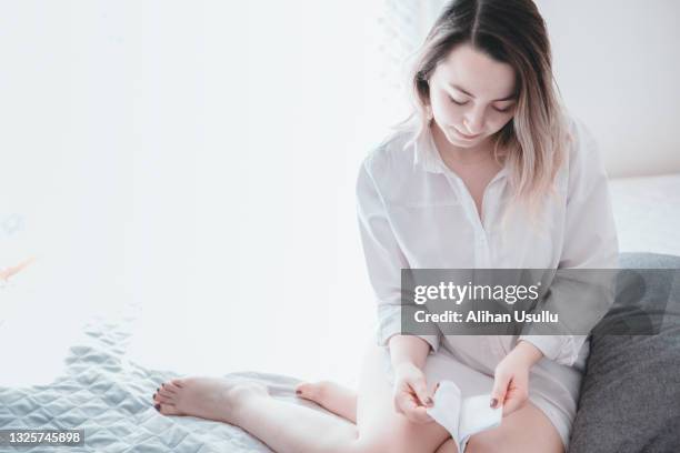 young woman opening pad on bed - padding stock pictures, royalty-free photos & images