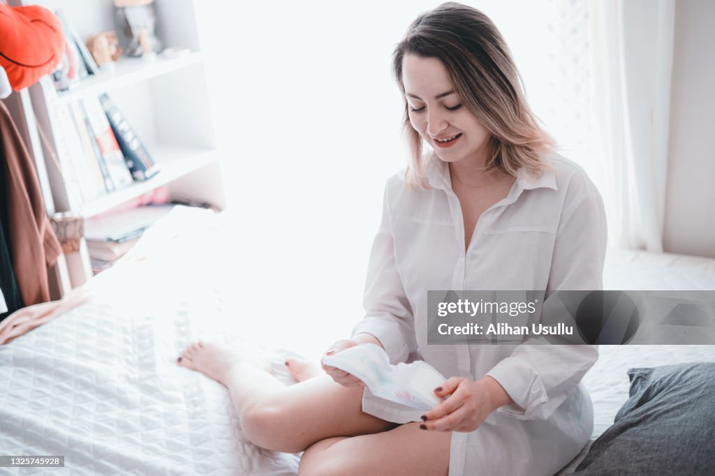 ベッドの上の若い女性の開口パッド