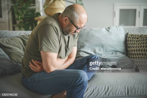 hombre adulto maduro (enfermedad, dolor de estómago) - stomachache fotografías e imágenes de stock