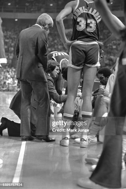 Head Coach Jerry West kneels in front of his team’s bench during a timeout in an NBA basketball game between the Denver Nuggets and the Los Angeles...