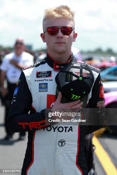 Ty Gibbs, driver of the Joe Gibbs Racing Toyota, stands during the national anthem on the grid prior to the NASCAR Xfinity Series Pocono Green 225...