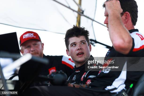 Harrison Burton, driver of the DEX Imaging Toyota, and crew chief Jason Ratcliff talk in the pit box after an on-track incident during the NASCAR...