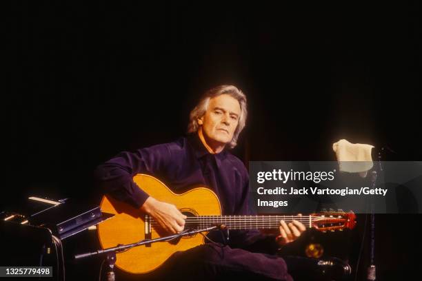 English Jazz and Fusion musician, composer, and band leader John McLaughlin plays acoustic guitar as he performs onstage at Avery Fisher Hall at...