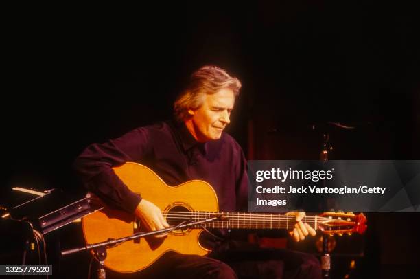 English Jazz and Fusion musician, composer, and band leader John McLaughlin plays acoustic guitar as he performs onstage at Avery Fisher Hall at...