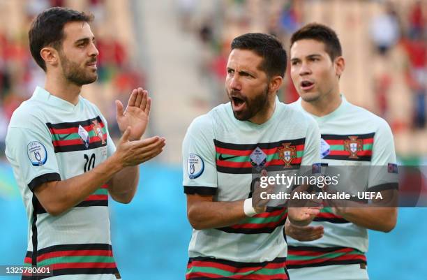 Bernardo Silva, Joao Moutinho and Raphael Guerreiro of Portugal react after singing the national anthem prior to the UEFA Euro 2020 Championship...