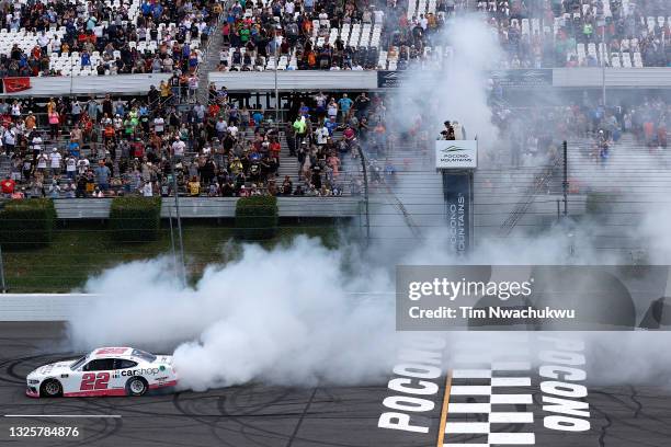 Austin Cindric, driver of the Car Shop Ford, celebrates with a burnout after winning the NASCAR Xfinity Series Pocono Green 225 Recycled by J.P....