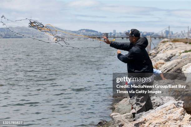 Jasyn De Guzman, of Hayward, nets smelt on a parcel of land that was used as a taxiway at the former Naval Air Station Alameda in Alameda, Calif., on...