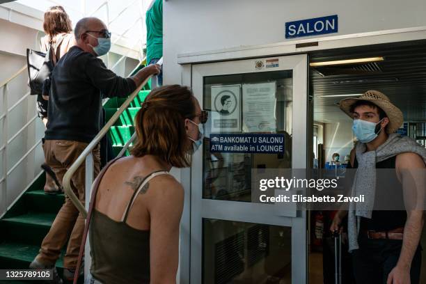 French tourists, wearing face masks, enter the domestic ferry connecting Split to Brac island on June 27, 2021 in Croatia. Anti-Covid regulations and...