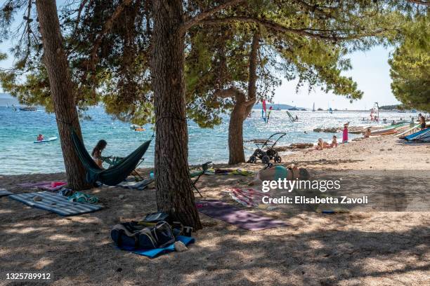 Tourists enjoy the pinewood shadows on one of the town's beaches on June 27, 2021 in Bol, Croatia. Croatia has already reported a 40 percent increase...