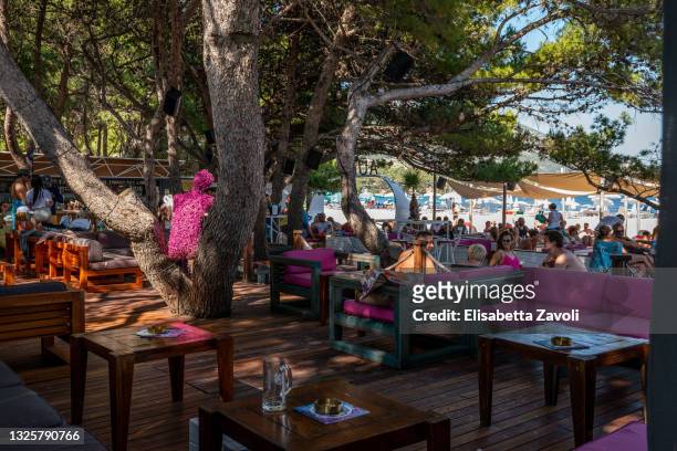 Tourists enjoy a drink at the Auro Bar on Zlatni Rat beach on June 27, 2021 in Bol, Croatia. Croatia has already reported a 40 percent increase in...