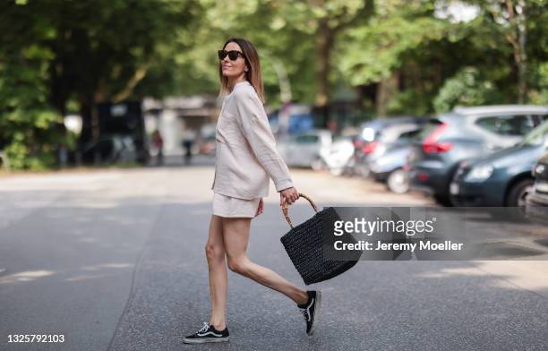Elise Soho wearing black low Vans sneakers, beach bag and beige Soho Studios two piece on June 26, 2021 in Hamburg, Germany.