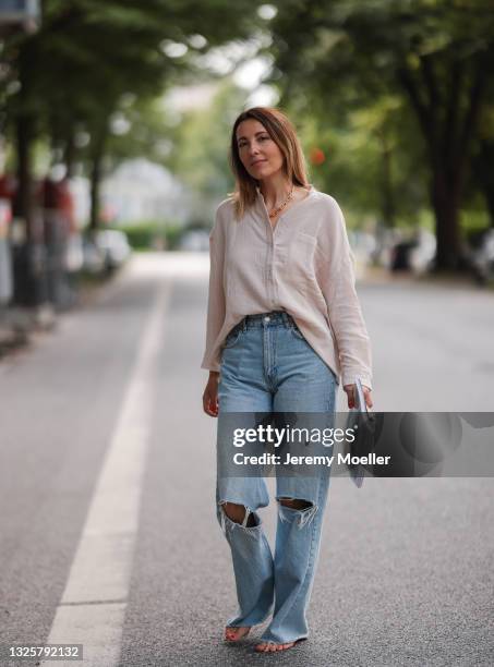 Elise Soho wearing light pink Soho Studios linen shirt and blue Zara destroyed jeans on June 26, 2021 in Hamburg, Germany.