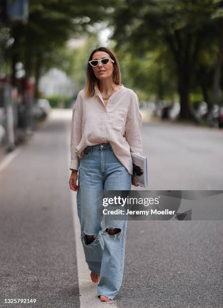 Elise Soho wearing light pink Soho Studios linen shirt and blue Zara destroyed jeans on June 26, 2021 in Hamburg, Germany.