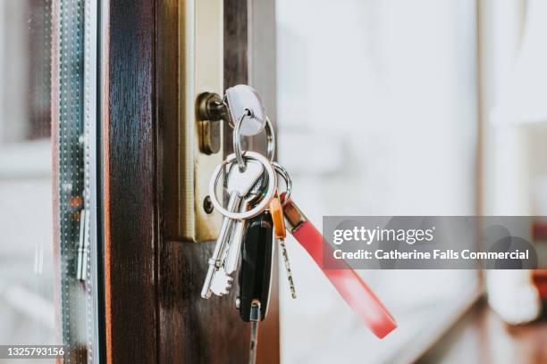 bunch of keys hanging in a glass door - locksmith stock pictures, royalty-free photos & images