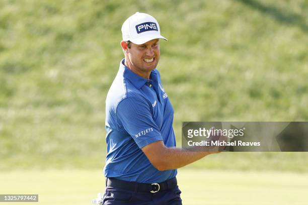 Harris English of the United States reacts to his birdie putt on the 18th green during the final round of the Travelers Championship at TPC River...