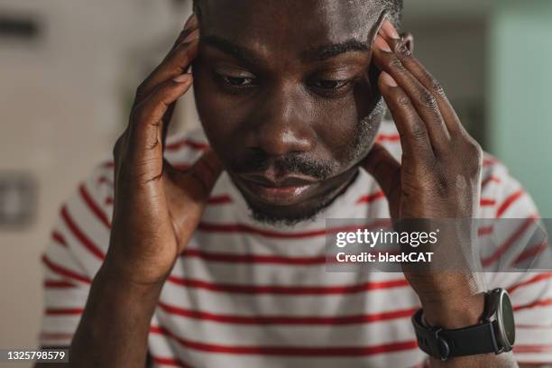 young guy has a stressful day and headache - winter blues stock pictures, royalty-free photos & images