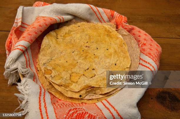 freshly made corn tortillas in a tea towel and basket - tortilla stock pictures, royalty-free photos & images