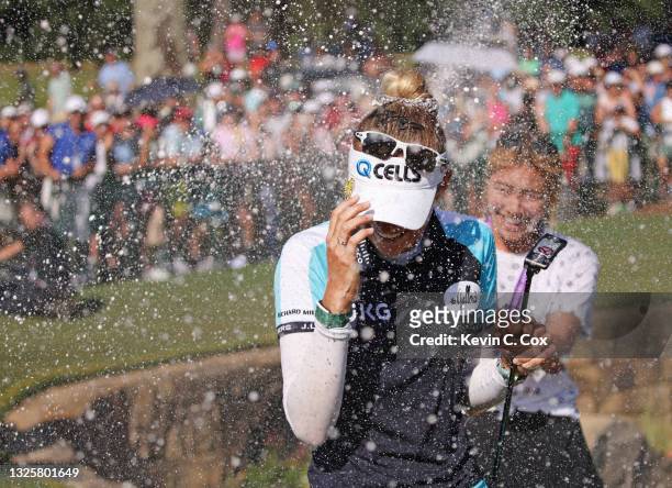 Nelly Korda is doused with Champagne after putting in to win on the 18th green during the final round of the KPMG Women's PGA Championship at Atlanta...