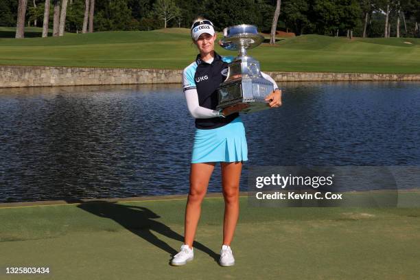 Nelly Korda poses with the trophy after putting in to win on the 18th green during the final round of the KPMG Women's PGA Championship at Atlanta...