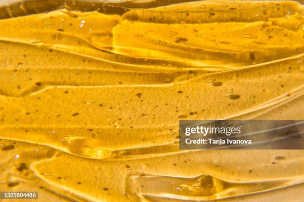 texture cosmetic cream gel on orange background. liquid orange wax or sugar paste for depilation. the concept of depilation, waxing, sugaring smooth skin without hair, banner. - honey stock pictures, royalty-free photos & images