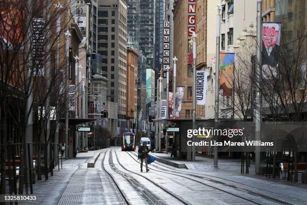 Pedestrian moves along an almost empty George Street in the CBD on June 28, 2021 in Sydney, Australia. Lockdown restrictions continue across Great...