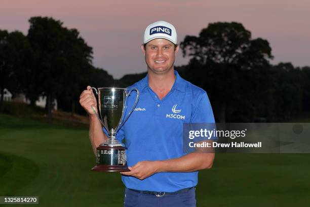 Harris English of the United States poses with the trophy after winning the Travelers Championship on the eighth playoff hole over Kramer Hickok of...