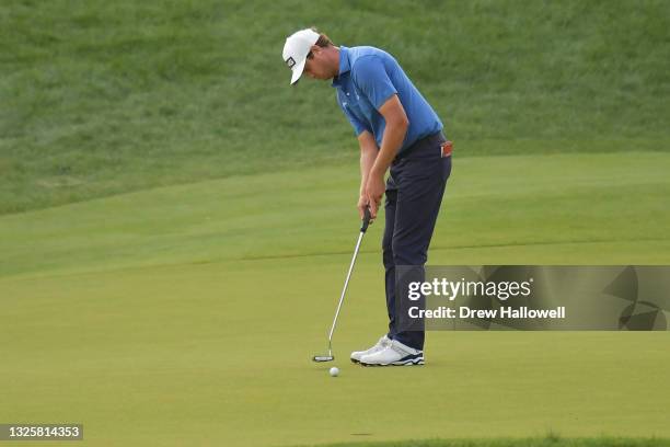 Harris English of the United States putts on the 18th green in the eighth playoff hole during the final round of the Travelers Championship at TPC...