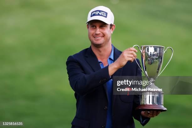 Harris English of the United States poses with the trophy after winning the Travelers Championship on the eighth playoff hole over Kramer Hickok of...