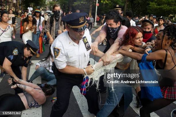 Police clash with revelers during Gay Pride festivities after trying to clear a street on the edge of Washington Square Park on June 27 in the...