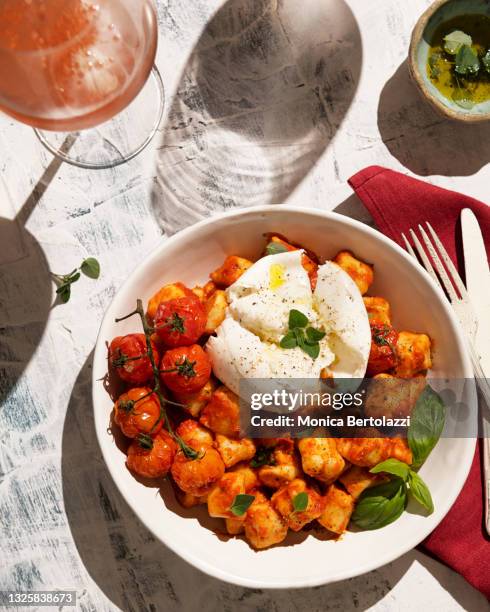 gnocchi with tomato sauce, mozzarella and herbs - auf dem tisch stock-fotos und bilder