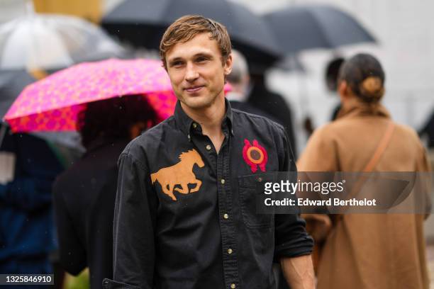 Actor William Moseley wears a black shirt with brown suede horse embroidered and red / brown embroidered circle, outside Hermes, during Paris Fashion...