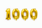 Number 1000 one thousand golden foil balloon party decor on white background, birthday anniversary