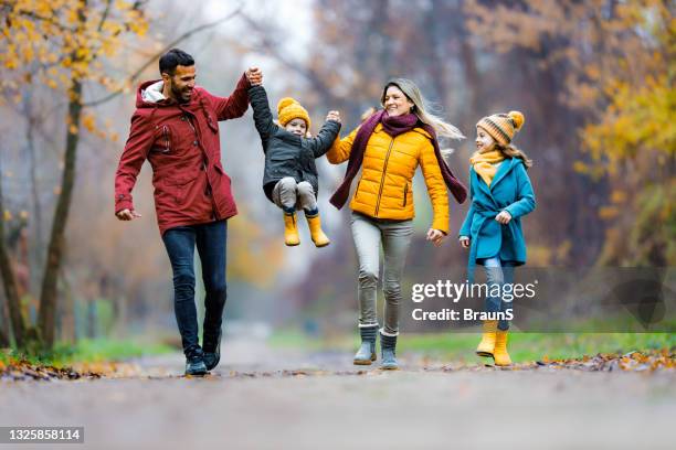 carefree family having fun in winter day at the park. - family walking stock pictures, royalty-free photos & images