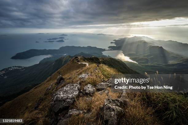 sunbeam shining on mountains near shek pik reservoir in lantau island, hong kong, from peak of lantau peak - lantau stock pictures, royalty-free photos & images