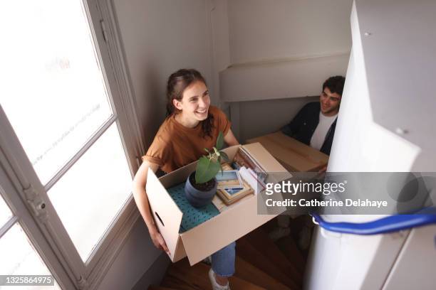 a happy young couple moving into a new apartment - moving house stock pictures, royalty-free photos & images