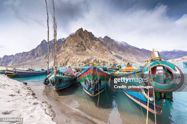 bateau en bois coloré au lac bleu attabad dans les montagnes pakistanaises de la vallée de hunza - gilgit baltistan photos et images de collection