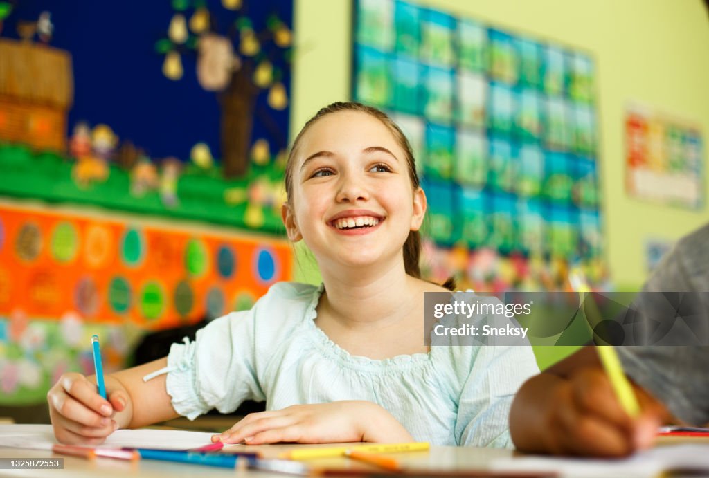 Uma colegial bonita está ouvindo a lição.