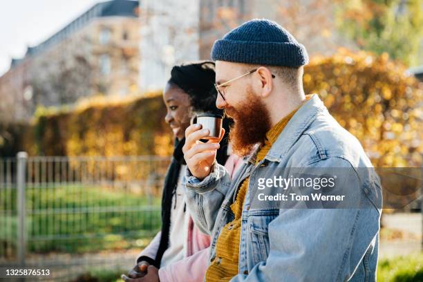 father drinking coffee from flask while out at park - facial hair in women stock pictures, royalty-free photos & images