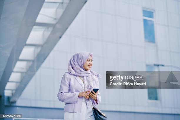 young businesswoman on the move - working from mobile phone - indonesia business stock pictures, royalty-free photos & images