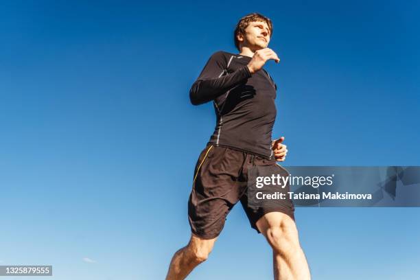man running on sky background. - man blue background fotografías e imágenes de stock