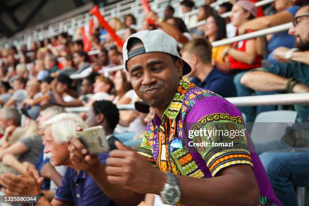 man taking selfies at a footbal match - football phone stock pictures, royalty-free photos & images