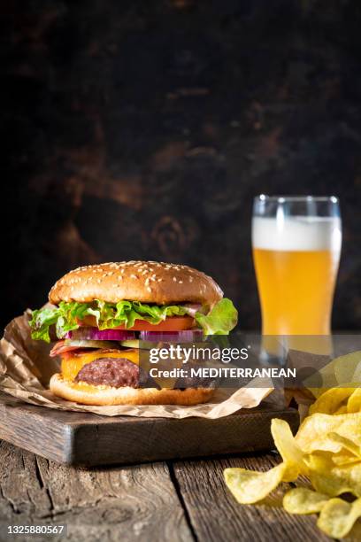 cheeseburger burger patty clásico con patatas fritas y menú de cerveza en mesa rústica de madera - hamburguesa-con-queso fotografías e imágenes de stock