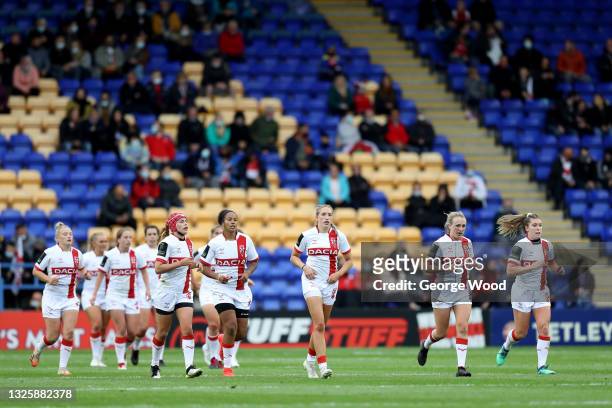 Players of England run back after scoring a try during the Rugby League International match between England Women and Wales Women at The Halliwell...