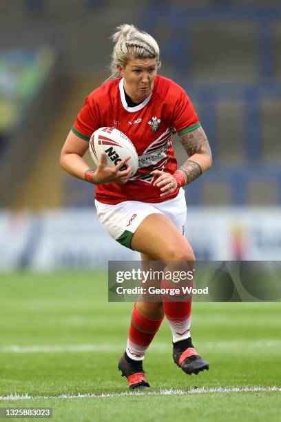 Lauren Aitken of Wales runs with the ball during the Rugby League International match between England Women and Wales Women at The Halliwell Jones...