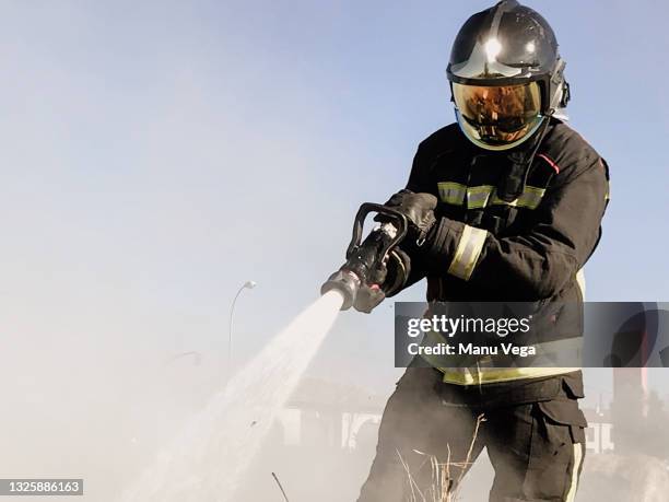 firefighters extinguishing a dangerous fire - forest firefighter stock pictures, royalty-free photos & images