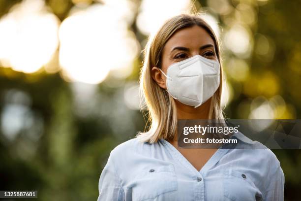 disfrutando de un hermoso día al aire libre en el parque público - mascarilla n95 fotografías e imágenes de stock