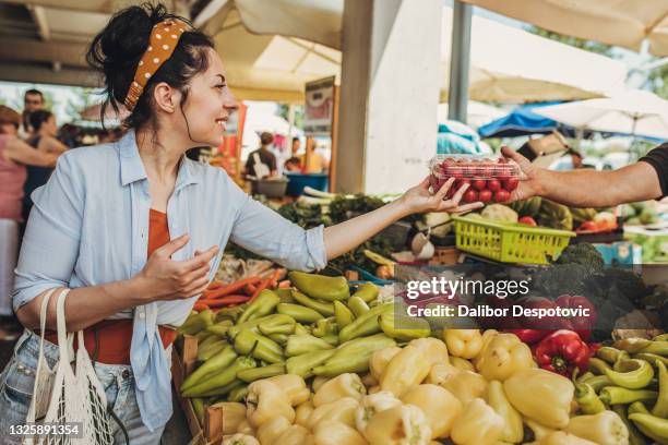 a young woman buys vegetables and fruits at the market . - sustainable livelihood stock pictures, royalty-free photos & images