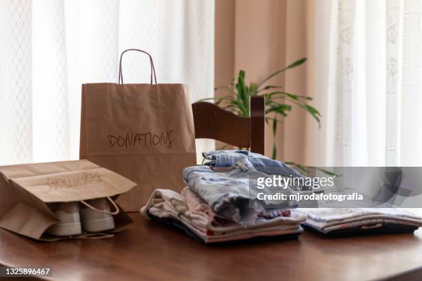 folded clothes on the table ready to donate - oggetti personali foto e immagini stock